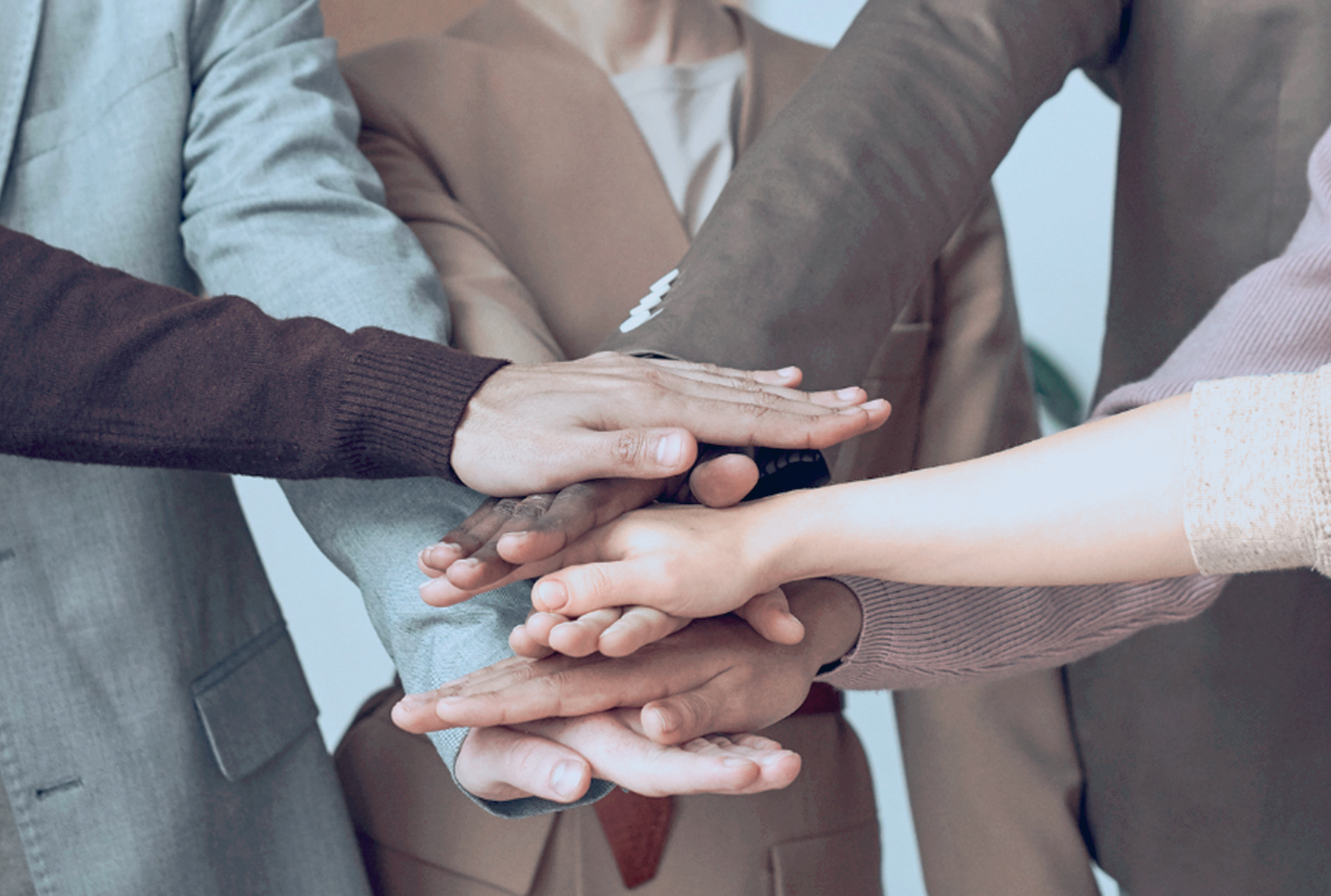 Grupo de gente con las manos agrupadas y apiladas
